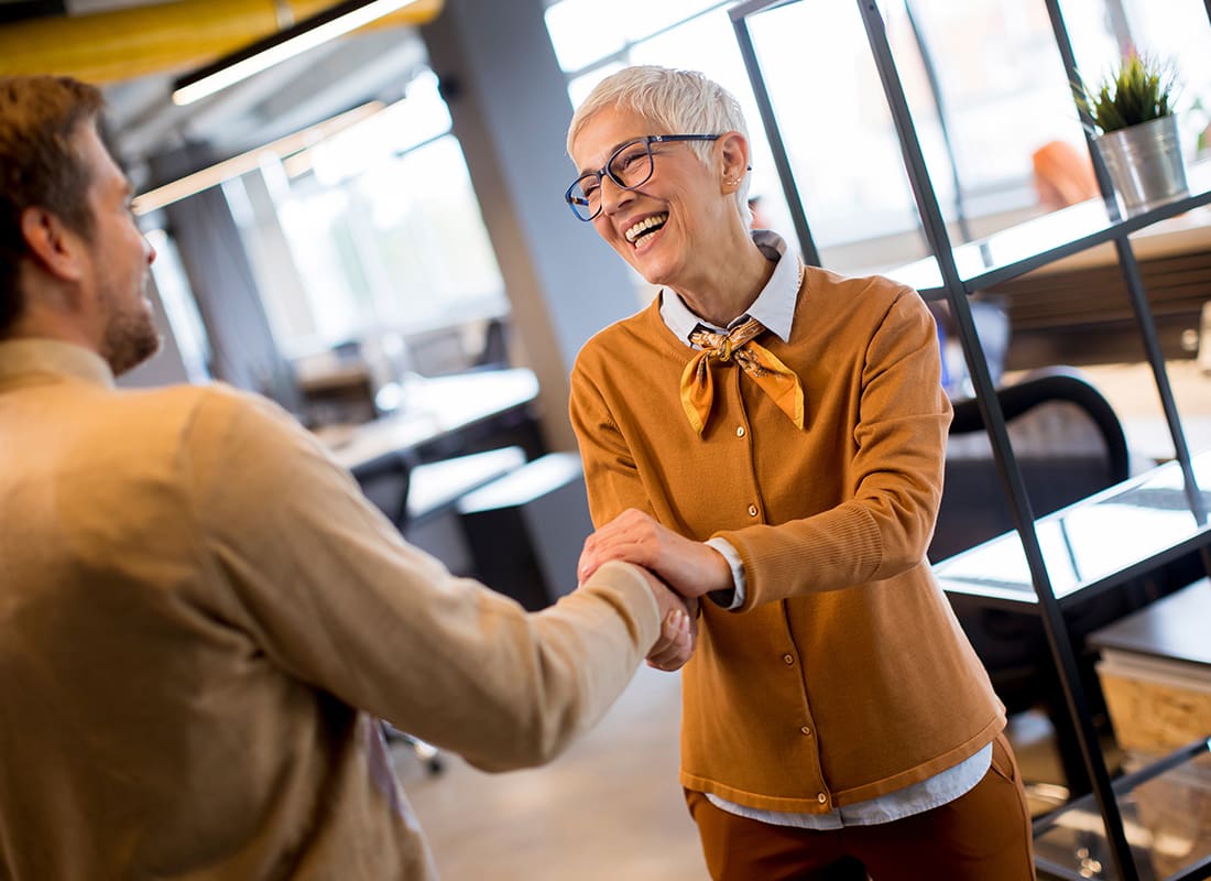 Contact - Cheerful Woman Shakes Hands With a Client